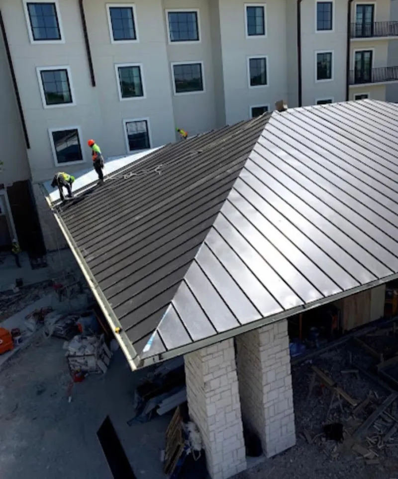 Crew installing standing seam metal roof panels on a commercial project in Winter Garden